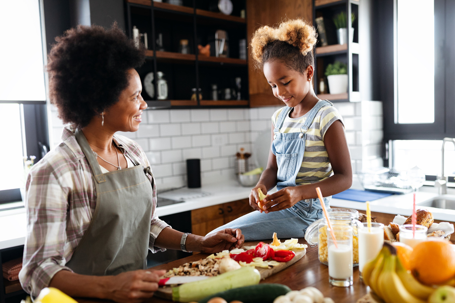 Mãe e filha na cozinha preparando receitas para o dia das mães juntas.